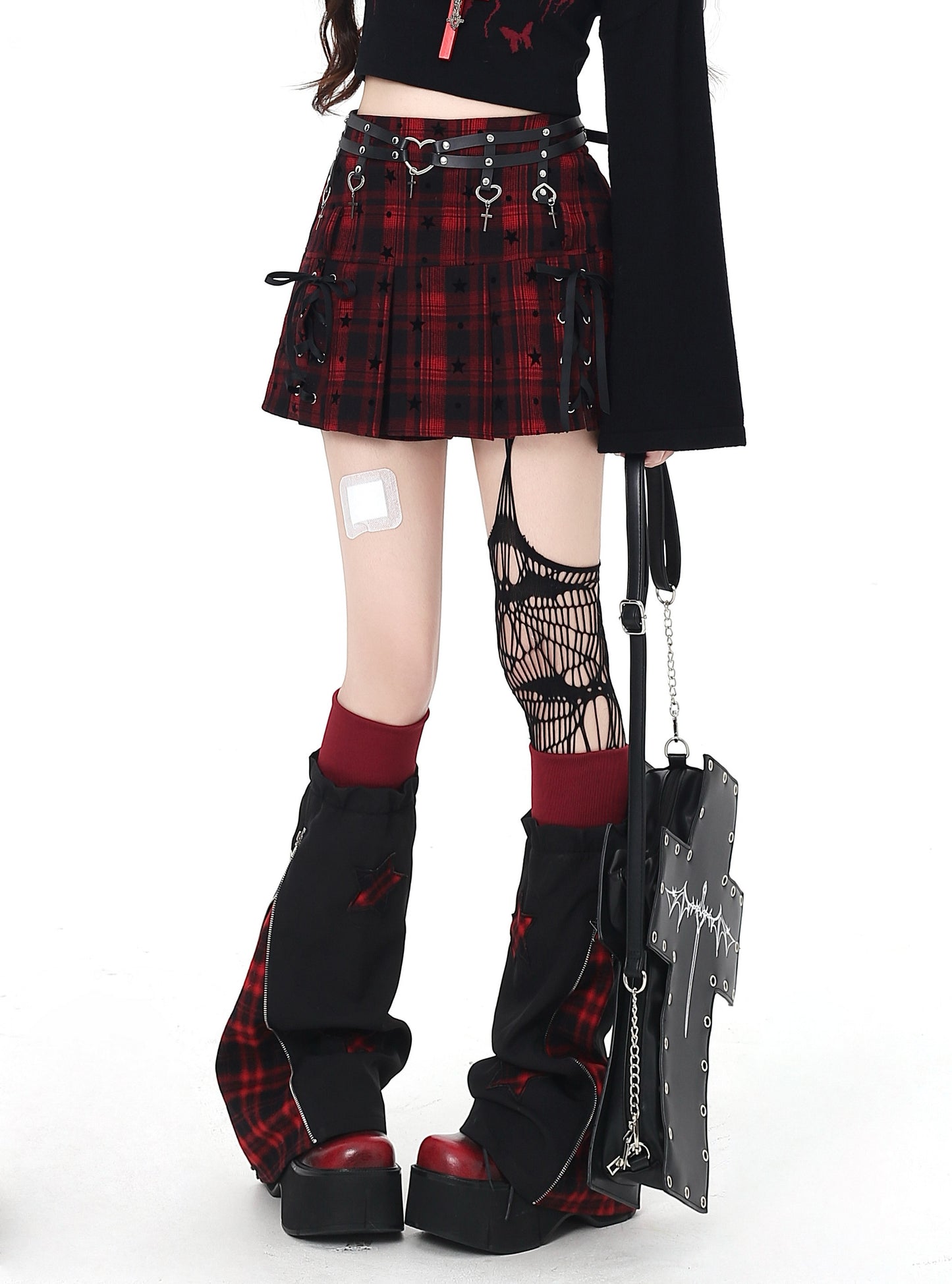 Person wearing a red and black plaid skirt with platform boots and holding an umbrella on a white background