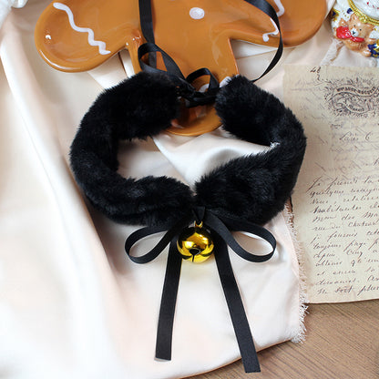 Black faux fur collar with a gold bell on a textured surface