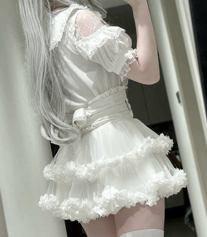 Person wearing a white lace dress with a fluffy skirt, standing indoors.