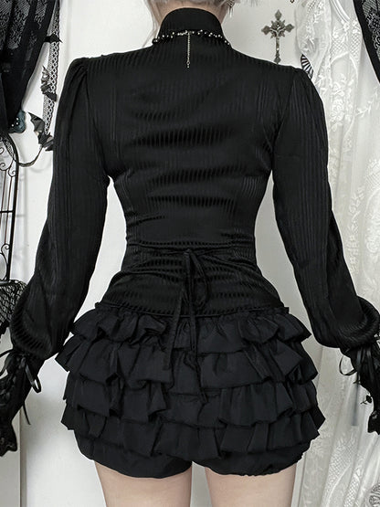 Black Victorian-style dress with ruffled skirt and long sleeves on a white background