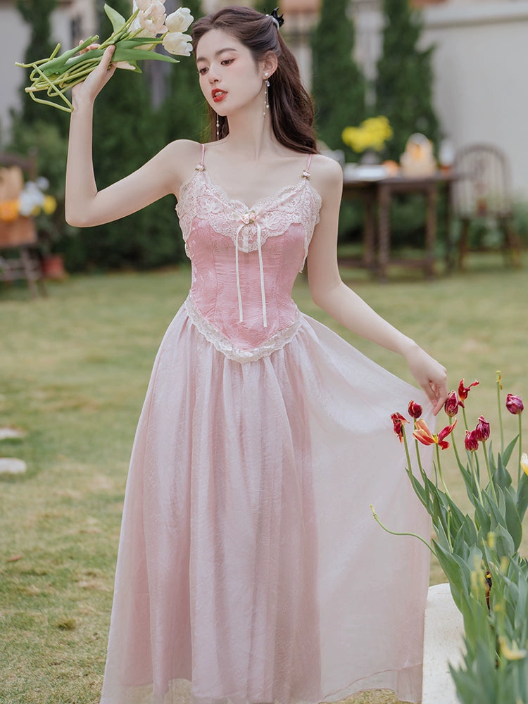 Woman in a pink dress holding flowers in an outdoor setting