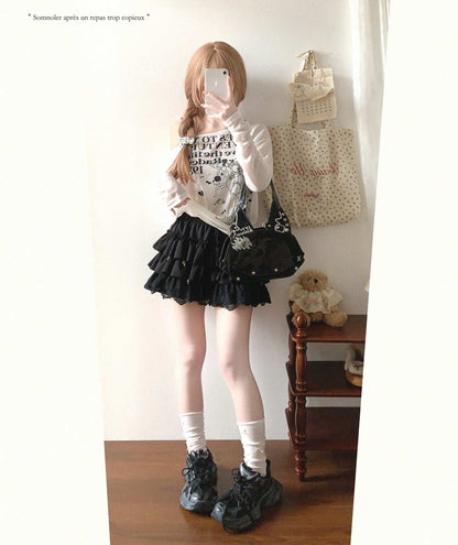 Person wearing a black skirt and white top in a room with a teddy bear and bags.