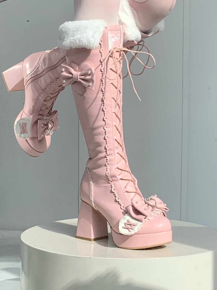 Pink lace-up boots with decorative elements on a white background