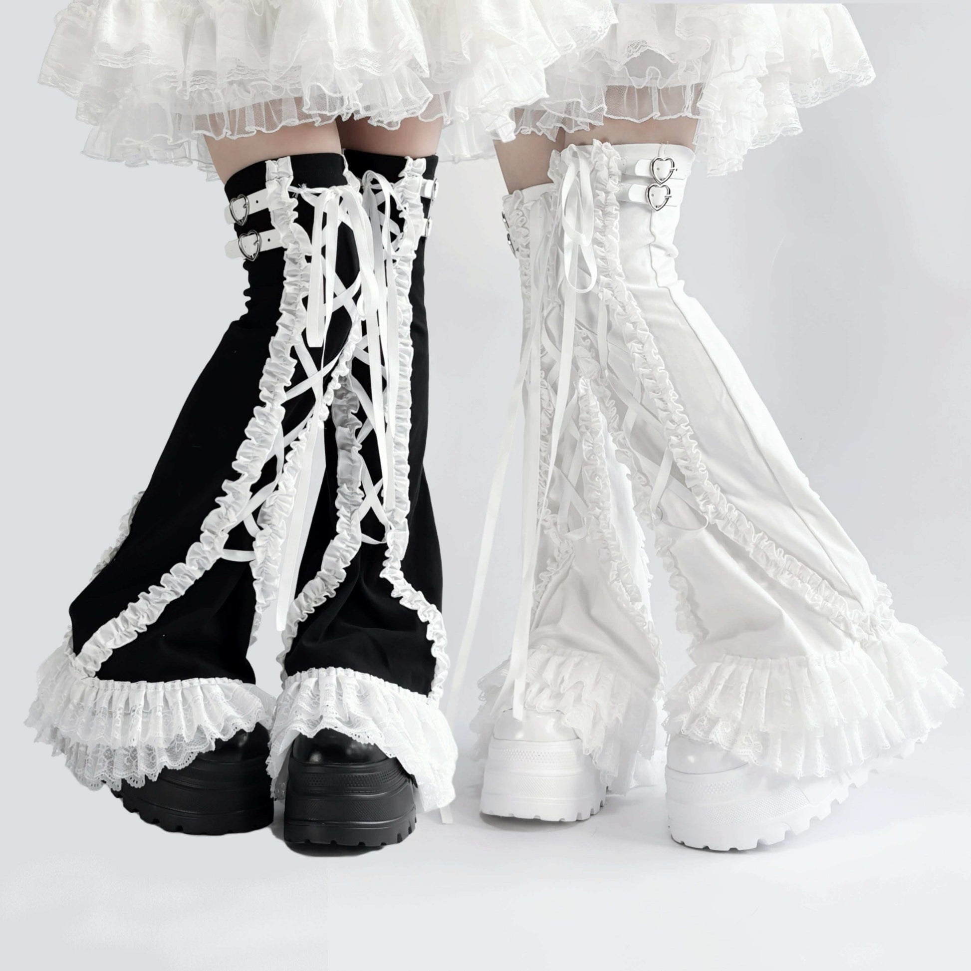 Black and white lace-up gaiters leg warmers worn with a white outfit on a light gray background