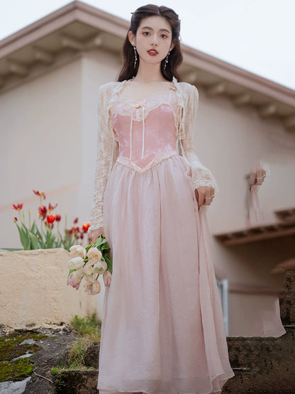 Woman in a pink dress holding flowers outdoors with a blurred background