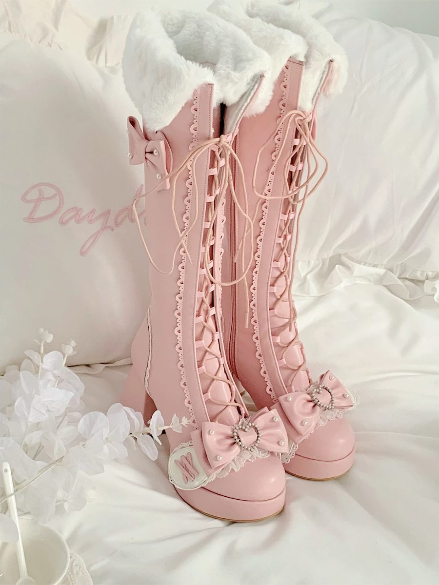 Pink lace-up boots with decorative bows on a white background