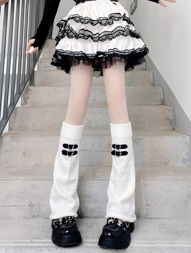 Person wearing a black and white outfit with knee-high socks and shoes on a staircase.