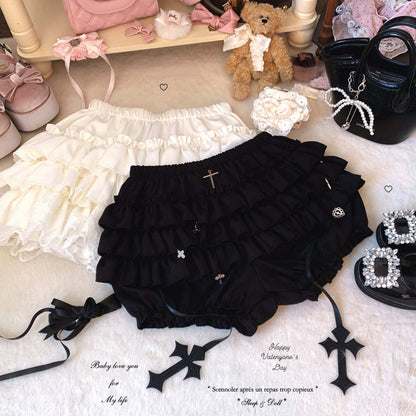 Black ruffled bloomers with decorative elements on a textured surface with accessories.