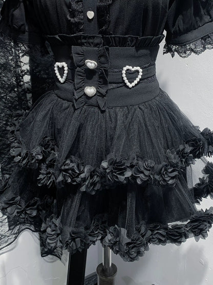 Black dress with floral details and heart-shaped buttons on a mannequin.