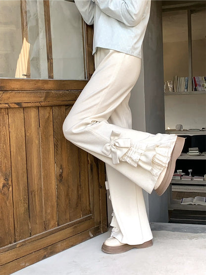Person wearing white pants and a light blue shirt in a room with wooden paneling and shelves.