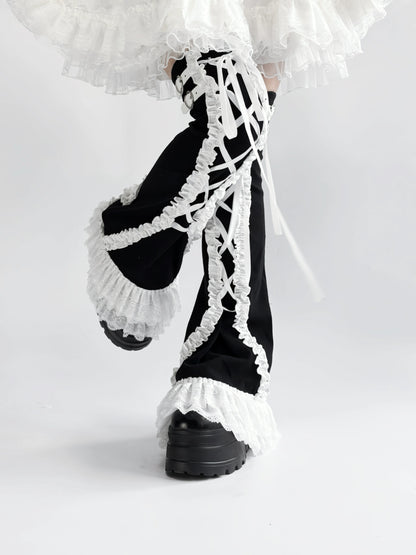 Black and white lace-up leg warmers with ruffled details on a white background