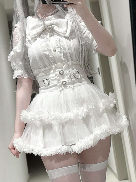Person wearing a white lace dress with a large bow in front of a mirror.