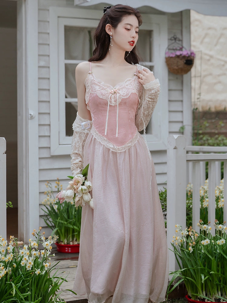 Woman in a pink vintage dress standing outdoors with flowers and a house in the background