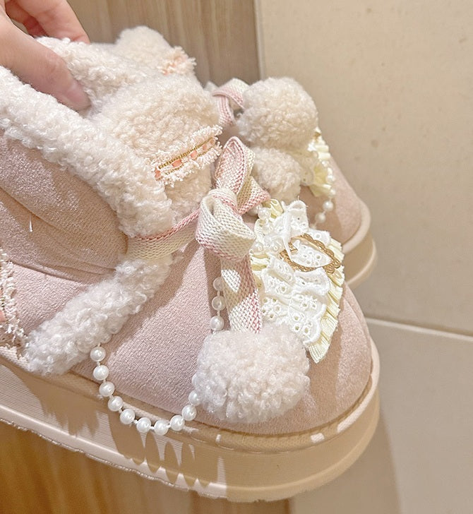 Pink winter boots with decorative elements on a light background