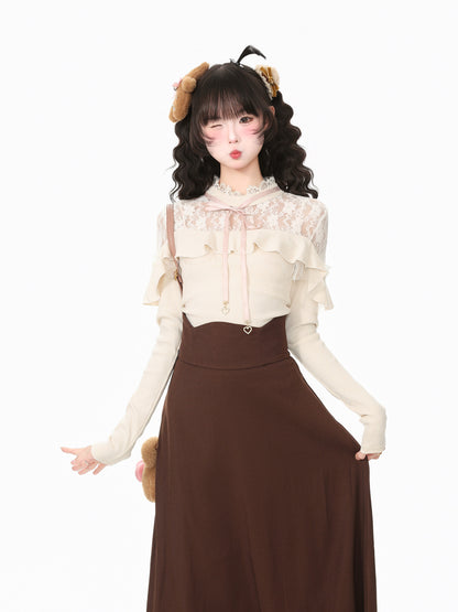 A young woman modeling a cream and brown outfit against a plain white background. She is wearing a cream long-sleeve blouse with lace and ruffle details, paired with a high-waisted brown skirt.