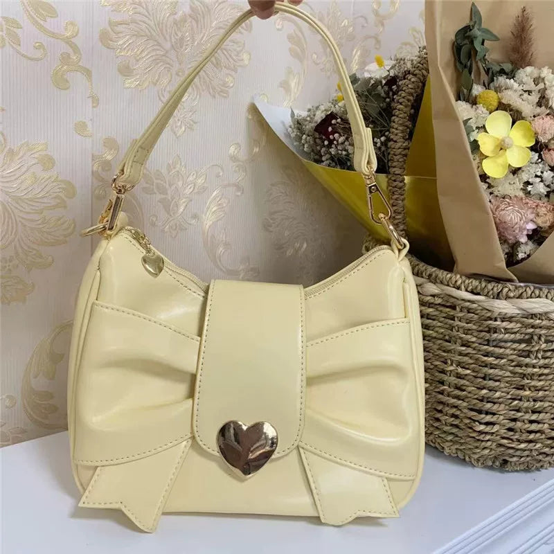 Beige handbag with a heart-shaped clasp on a decorative background