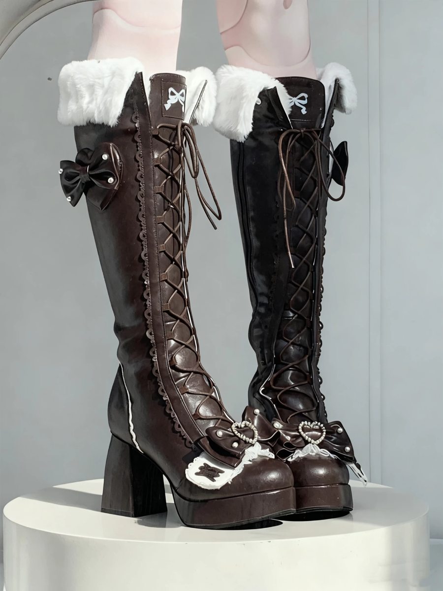 Pair of brown knee-high boots with white fur trim on a gray background