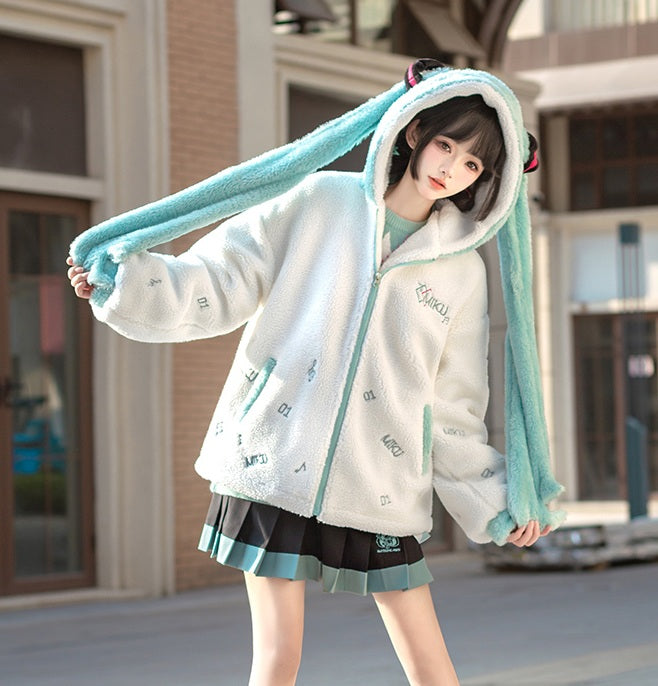 Person wearing a white fleece jacket with teal accents and bunny ears outdoors.
