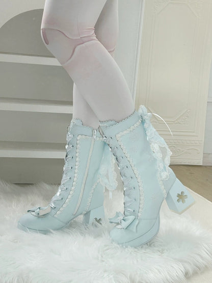 Light blue lace-up high-heeled boots worn with white tights and a light background.
