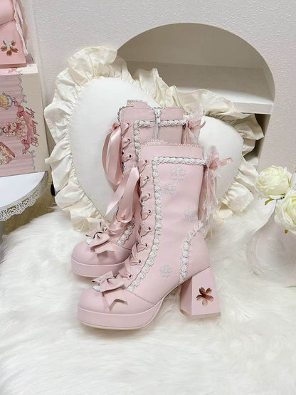 Pink lace-up boots with decorative elements on a soft white background