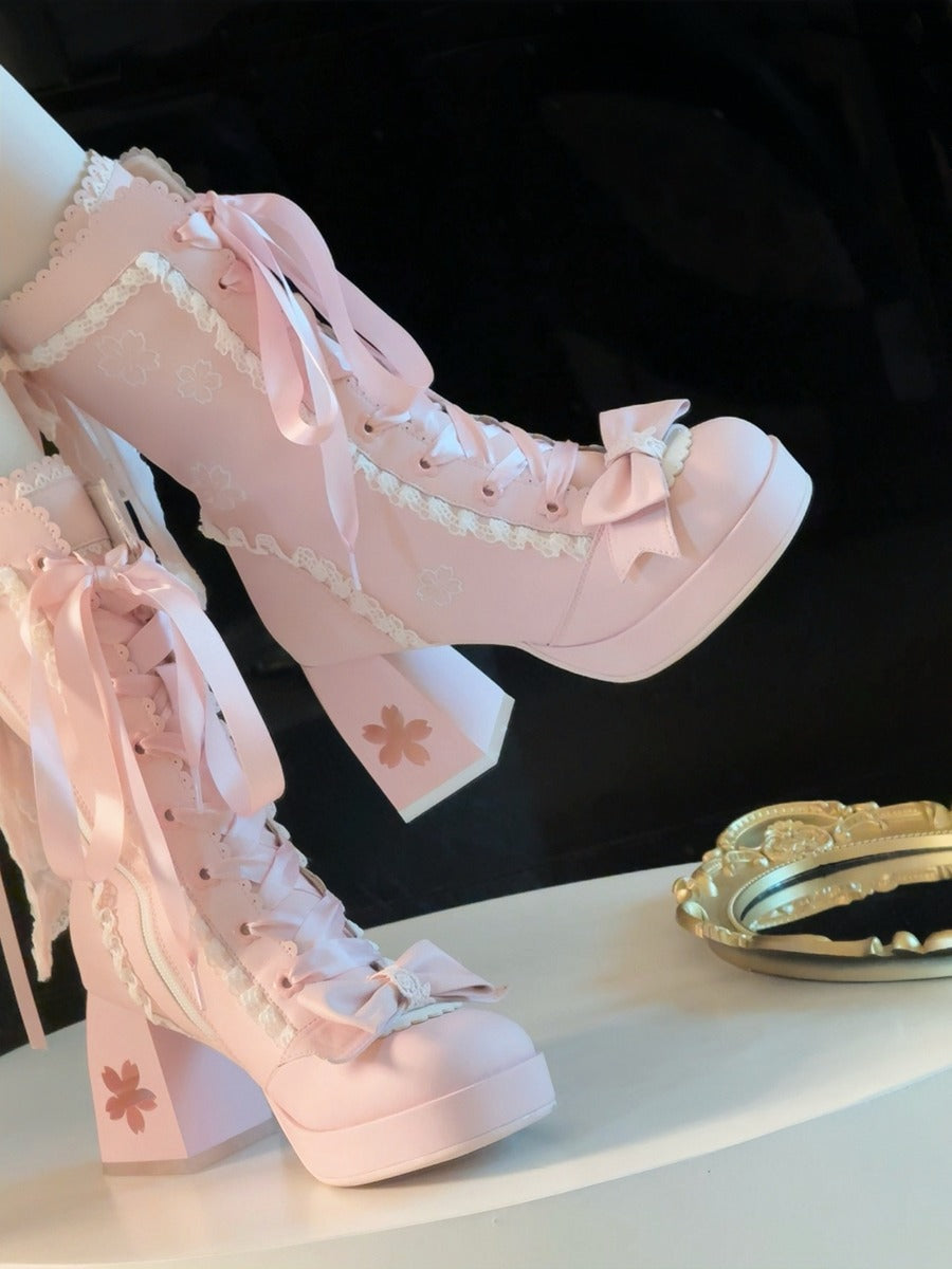 Pink high-heeled shoes with decorative ribbons and bows on a black background