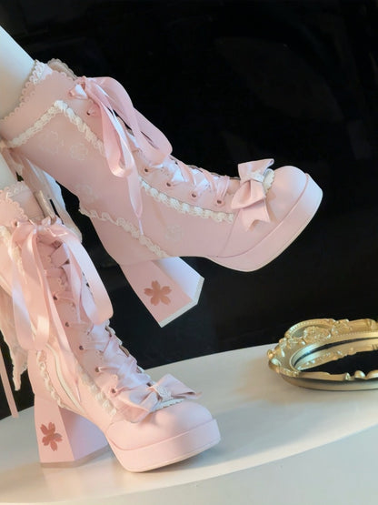 Pink high-heeled shoes with decorative ribbons and bows on a black background