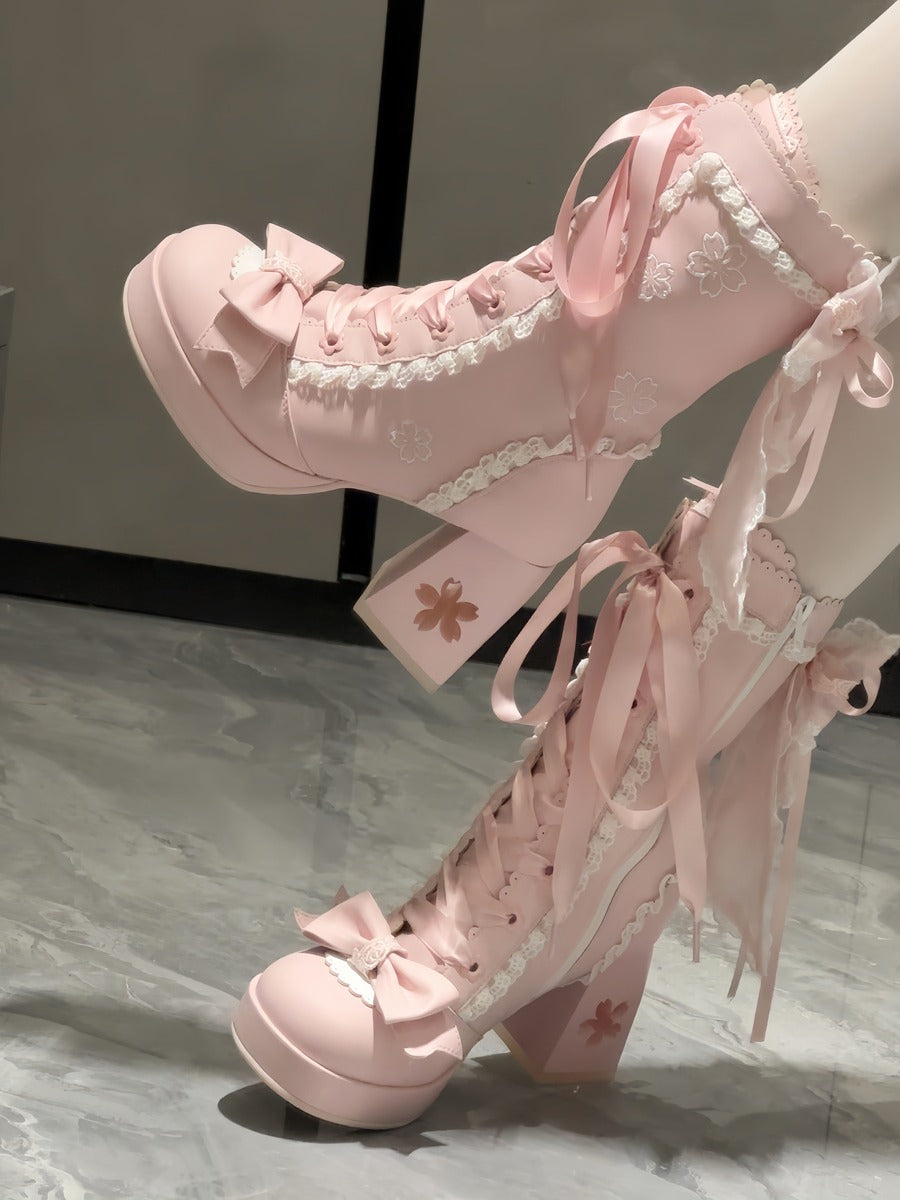 Pink lace-up shoes with ribbons on a marble surface