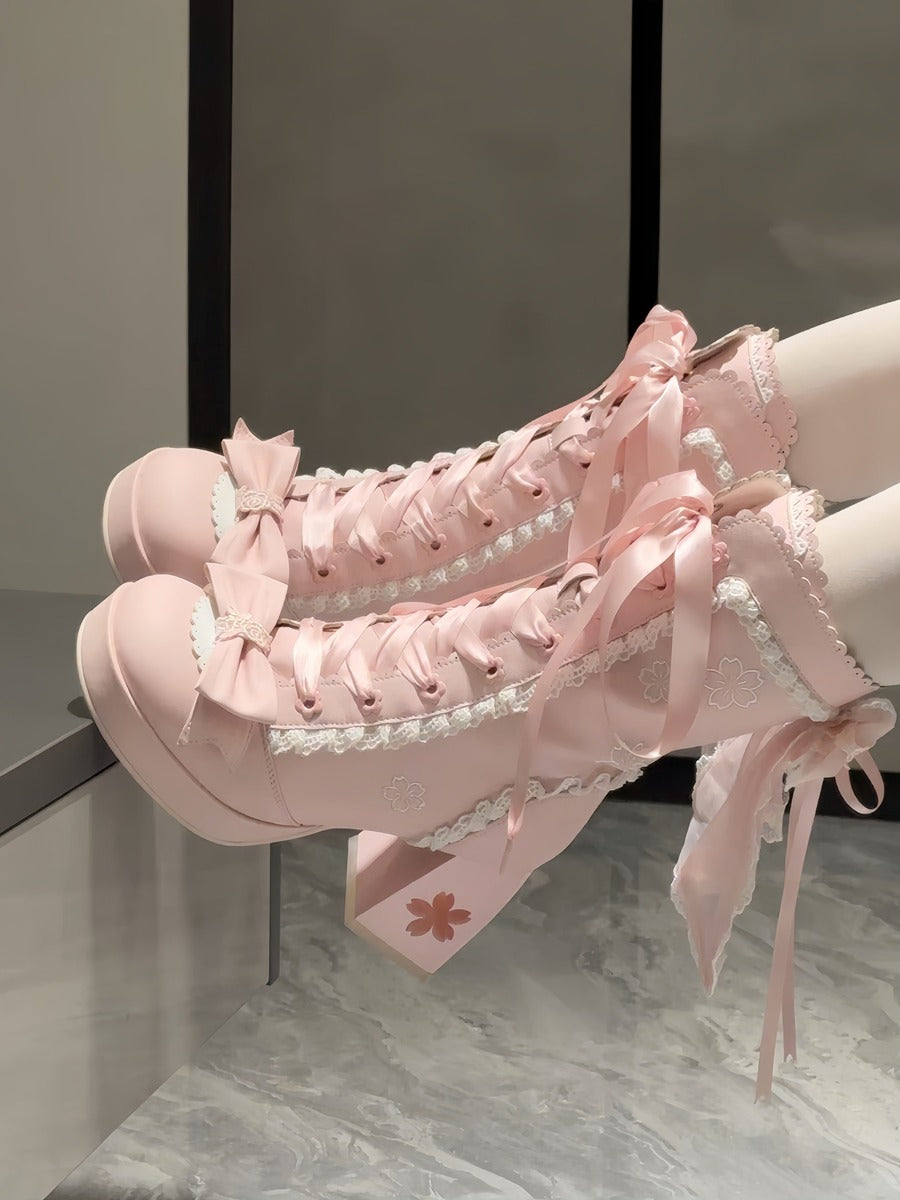 Pink high-heeled shoes with cherry blossom sakura lace details on a marble floor.