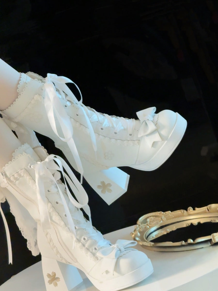 White lace-up boots with decorative elements on a black background