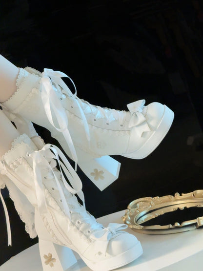 White lace-up boots with decorative elements on a black background