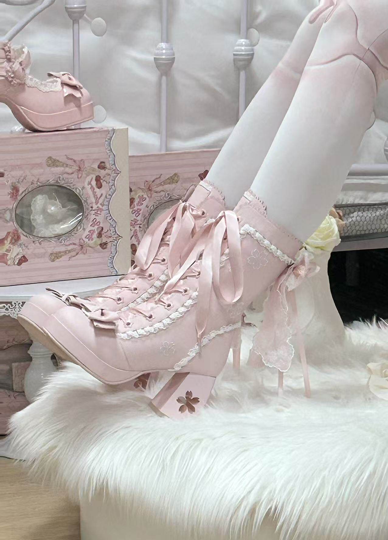 Pink lace-up shoes with white tights on a fluffy white surface.