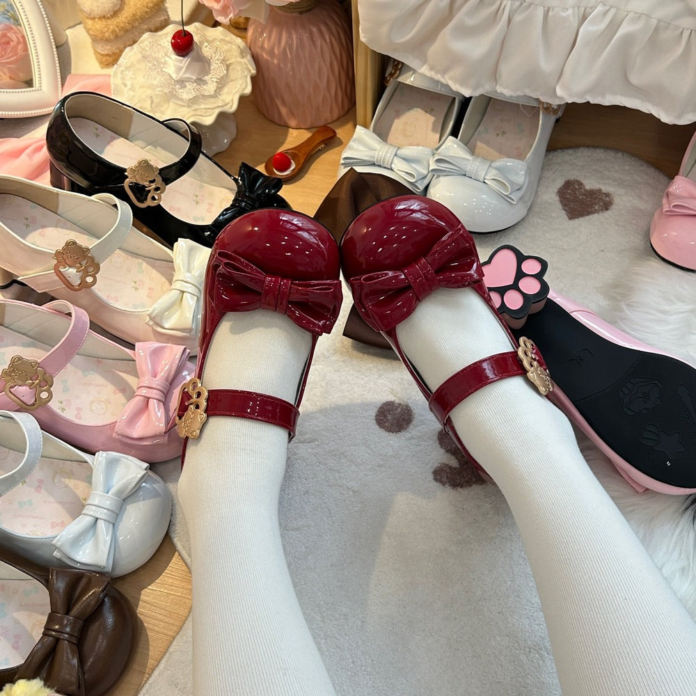 Children's shoes with decorative bows and straps on a wooden floor.