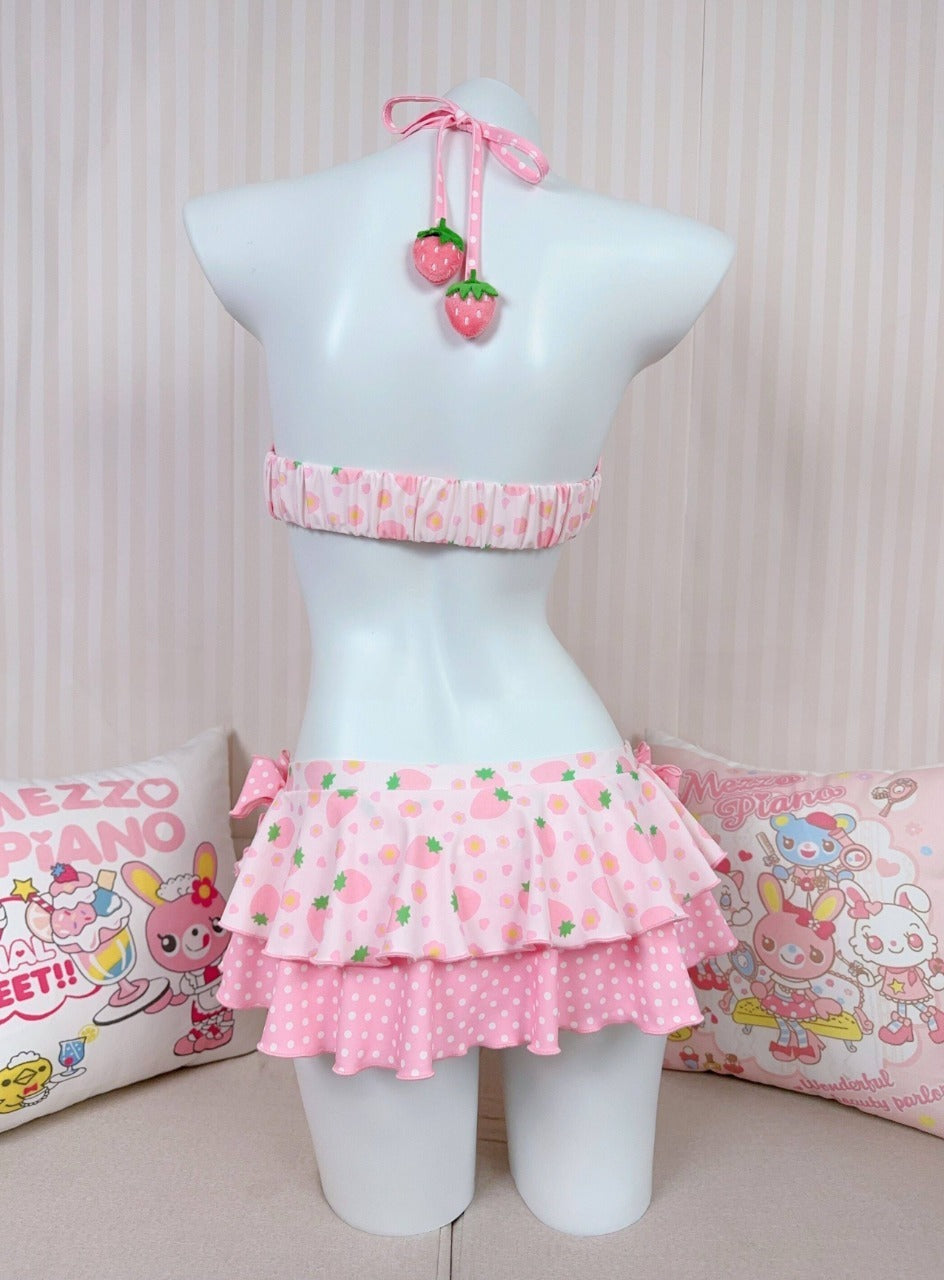 Mannequin wearing a pink polka dot outfit with a cherry design on a striped background