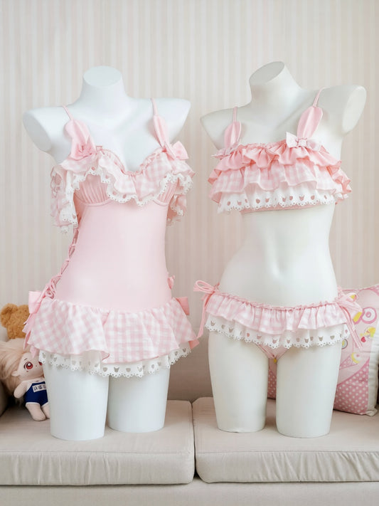 Two mannequins wearing pink lace lingerie set against a neutral background.