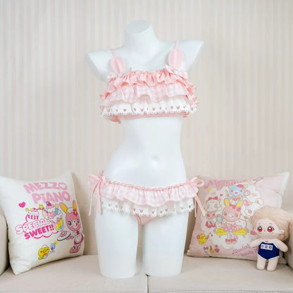 Mannequin wearing a pink ruffled outfit with cushions and a plush toy on a couch.