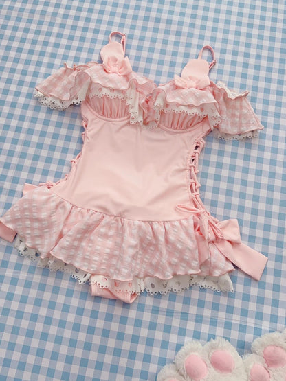 Pink swimsuit outfit with ruffles on a blue checkered background