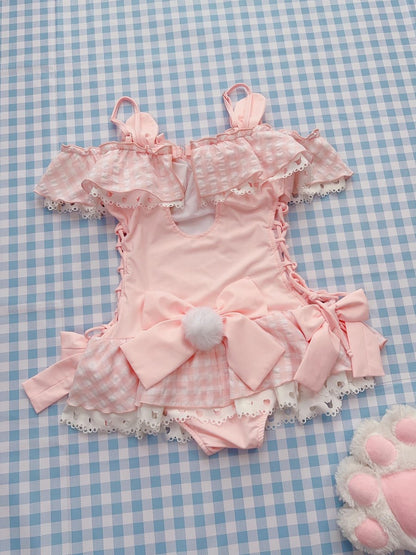 Pink swimsuit outfit with ruffles on a blue checkered background
