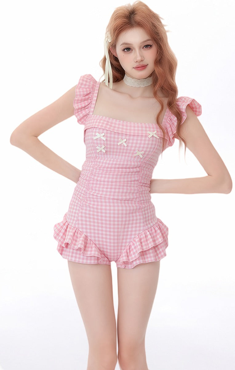 Woman wearing a pink checkered outfit with ruffled details on a white background