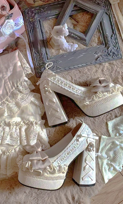 White lace-up high-heeled shoes on a textured surface with decorative elements.