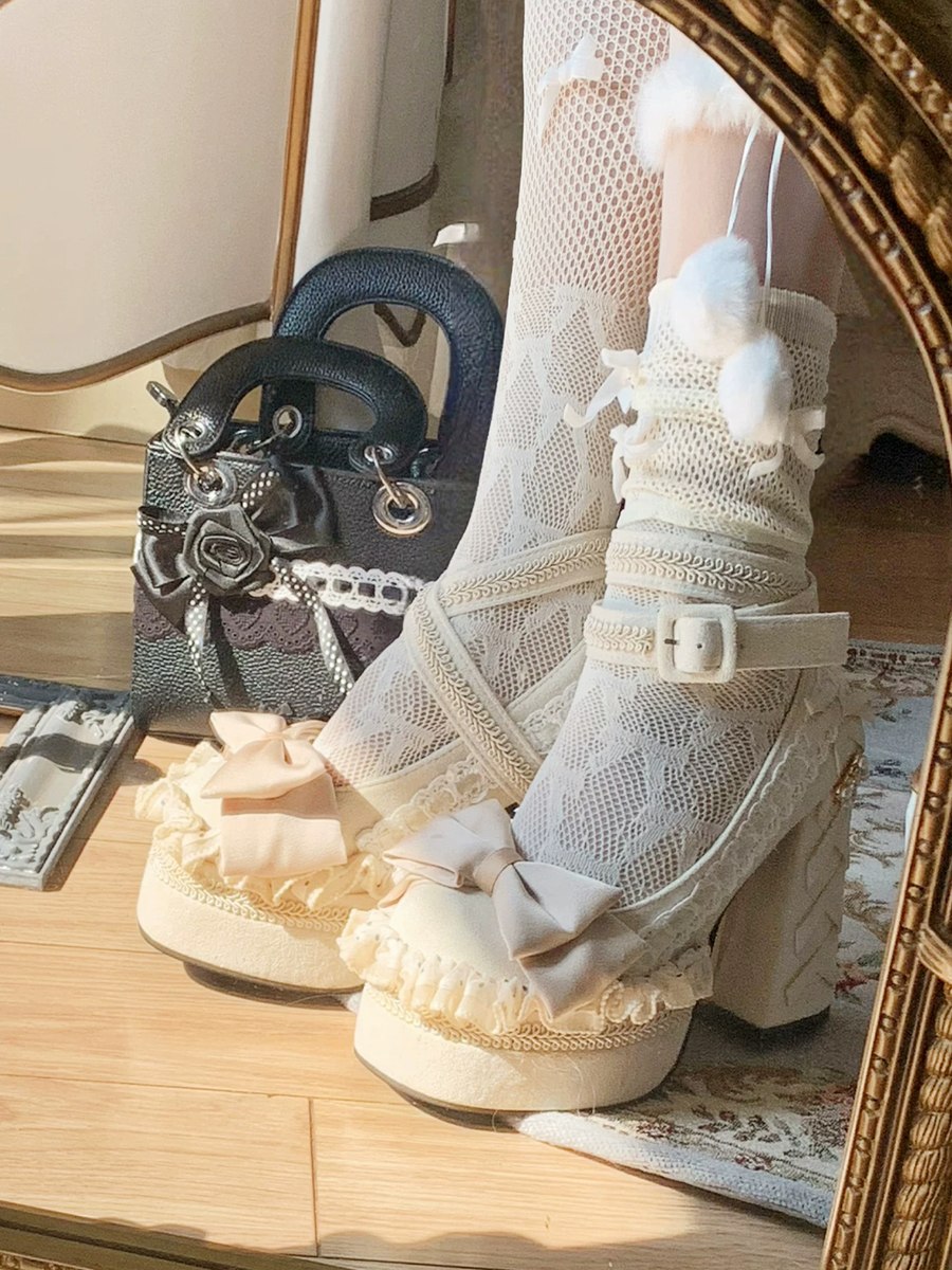 White lace-up shoes with decorative elements on a wooden surface.