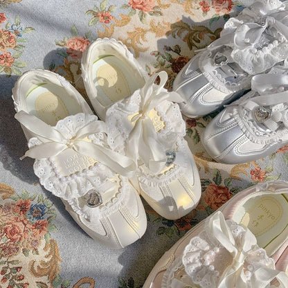 Pair of white lace-up shoes with decorative ribbons on a floral fabric background