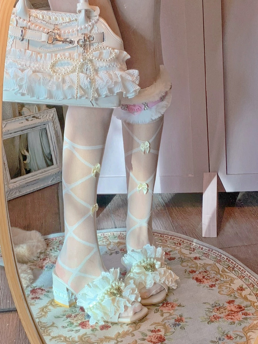 Person wearing a white lace dress, sheer stockings with floral patterns, and white shoes in a room.