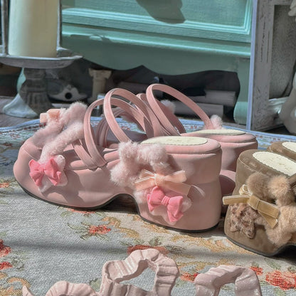 Pink women shoes with fluffy details and bows on a floral-patterned surface.