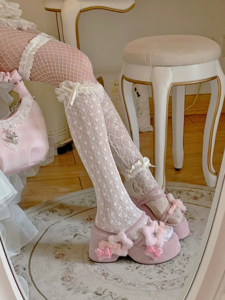 Person wearing pink floral slippers and fishnet stockings in a room with a mirror.