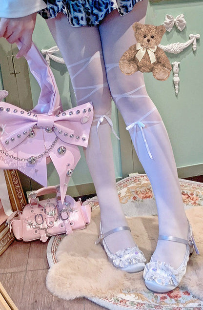 Person wearing white tights with decorative elements, holding a pink bag with bow details.