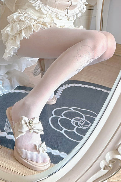 White sandal with decorative bow on a reflective surface