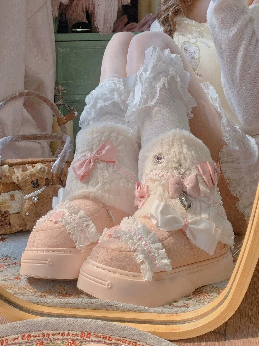 Pair of white ruffled shoes with pink bows on a wooden surface.
