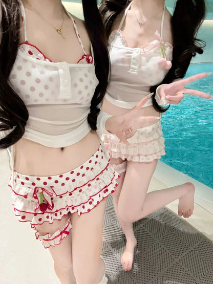 Two women in matching polka dot outfits by a pool.
