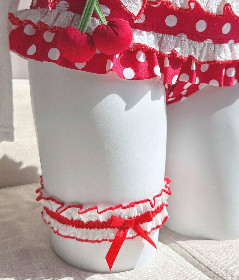 White cups with red polka dot and cherry designs on a light background