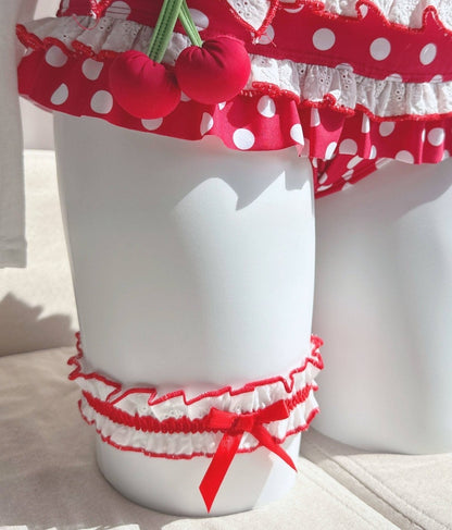 White cups with red polka dot and cherry designs on a light background